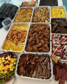 a table topped with trays of different types of food