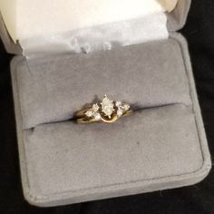 an engagement ring in a velvet box with the lid open and two diamonds on it