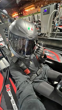 a man sitting in a racing car wearing a helmet