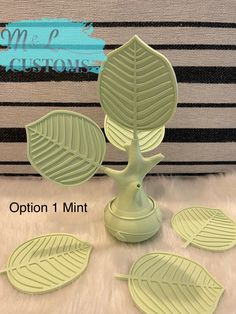 four green leaf shaped coasters sitting on top of a white rug