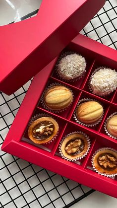 a red box filled with assorted pastries on top of a white countertop