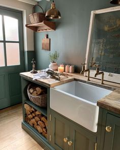 a kitchen with green painted walls and wooden flooring, an old fashioned farmhouse sink