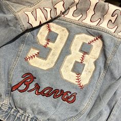 98 Braves Inspired Hand Painted JeanJacket.   PERFECT FOR:  >Country Concerts >Baseball Games FAQ:  >Hand wash with cool temperature. Avoid heat to paint  >Jackets are oversized.  >Image shown within listing is optional. Please contact me with specific illustration requests or ideas and I can design something that fits your needs! Inspirational photos will help speed the process along.  >Please contact me via Etsy conversation if there are any concerns regarding delivery date.  WHY ME?  >Ever since I was younger I loved to paint and design. I am a huge sports fan and always wanted something different from everyone else at the hockey or football games so I decided to paint my own.  People started stopping asking where I got my jacket, so I would love to create something wonderful and one of 98 Braves, Hand Painted Jean Jacket, Football Paintings, Painted Jean Jacket, Jean Art, Shoe Painting, College Gameday Outfits, Custom Jean Jacket, Why Me