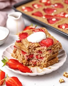 two pieces of strawberry crumb cake on a plate with strawberries next to it