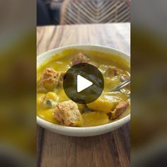 a white bowl filled with soup on top of a wooden table