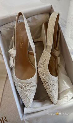 a pair of white wedding shoes in a box