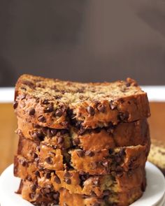 a stack of chocolate chip banana bread on a white plate next to some sliced bananas