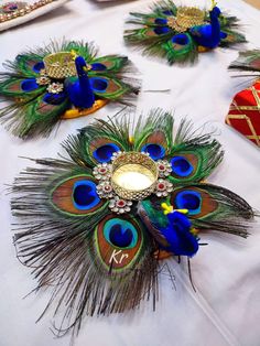 peacock feathers are arranged on a table with candles