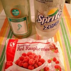 some raspberries are sitting next to a bottle of water and a bag of chips