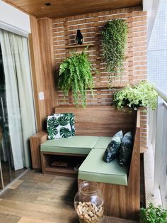 a wooden bench sitting next to a window filled with potted plants on top of a hard wood floor