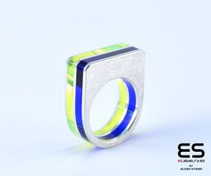 This ring is made of 3 hand cut slices of 925 sterling silver (1mm thick) and 2 slices of Acrylic Glass ( 3mm thick.) All slices are hand cut and fixed together with silver rivets.  The ring is 9 mm wide. The color combination is: Dark Blue and Neon Green  Reference code: PLE1SEA15 Available from ring size:     3 US  to 13 US 44 EU to 70 EU All ES Jewelry products  are shipped in our beautiful, branded packaging. Green Reference, Acrylic Rings, Acrylic Ring, Seal Ring, Branded Packaging, Green And Blue, Brand Packaging, Handmade Sterling Silver, Ring Handmade