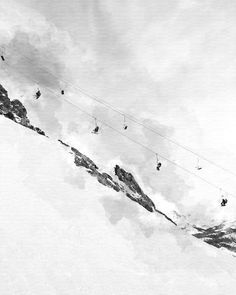 black and white photograph of people skiing down a snowy mountain with power lines above them