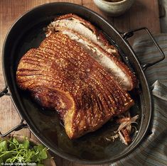 a large piece of meat sitting in a pan on top of a wooden table