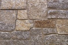 a stone wall that is made out of various types of stones and has different colors