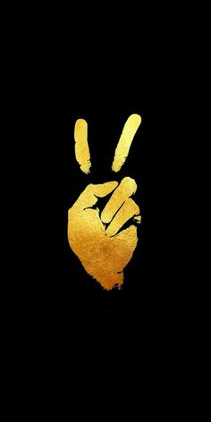 a gold peace sign painted on the side of a black wall in front of a dark background