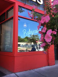 the front window of a restaurant with pink flowers