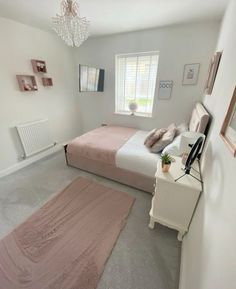 a bed room with a neatly made bed and a chandelier