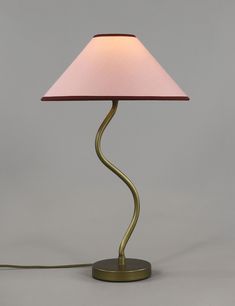 a lamp with a pink shade on it and a cord plugged into the base