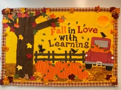 a woman standing in front of a bulletin board with fall leaves and pumpkins on it