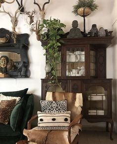 a living room filled with furniture and deer head mounted on the wall above it's shelves