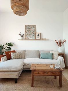 a living room with a couch, coffee table and pictures on the wall above it