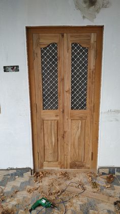 the front door is boarded up and ready to be installed with wood chips on the floor