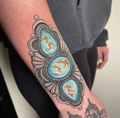 a woman's arm with tattoos on it and an image of dolphins in the water