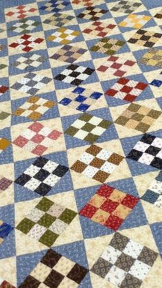 an old quilt is laying on the floor with it's blue and white checkered pattern