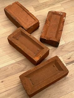 four pieces of brick sitting on top of a wooden floor