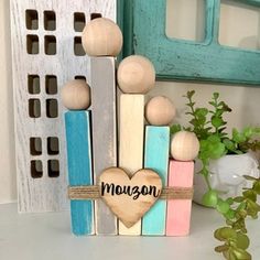 a group of wooden pegs sitting on top of a table next to a potted plant