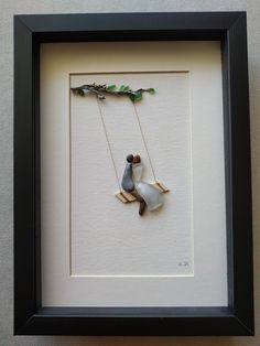 a framed photo with a bird on a swing