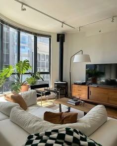 a living room filled with furniture and large windows