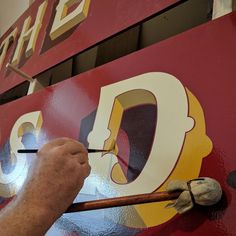 a man is painting the letters on a sign