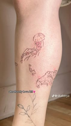 a woman's legs with tattoos on them, and the bottom half of her leg is