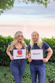 two women holding up signs with the words reality and instagram on them in front of some bushes