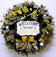 a welcome to our honeycomb wreath with yellow and black ribbons