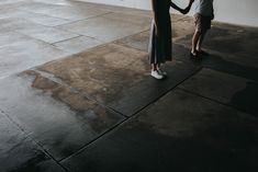 two people holding hands and walking on the sidewalk