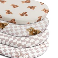 three teddy bears sitting on top of each other next to a white and gray checkered pillow