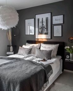 a bedroom with gray walls and pictures on the wall