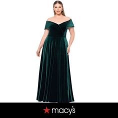 a woman wearing a green velvet dress with an off the shoulder top and pleaed skirt