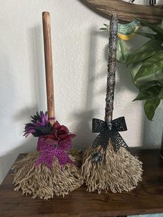 two mop heads on top of a wooden table next to a potted plant