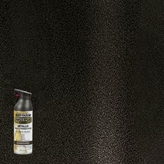 a black surface with a can of paint on it and a bottle of cleaner next to it