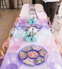 a table set up with plates, bowls and confetti dishes for desserts