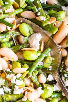 asparagus, beans and feta cheese in a bowl with two spoons