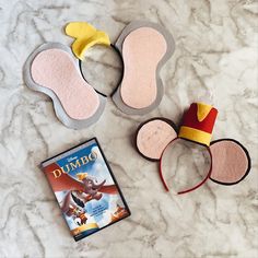 three mickey mouse ears, one for dumbo and the other for dumbo on a marble surface