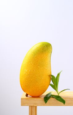 a yellow fruit sitting on top of a wooden table