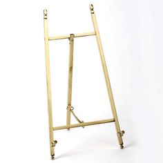 a gold metal easel with wheels on a white background