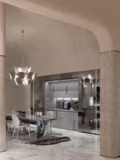 an elegant dining room with marble flooring and chandelier hanging from the ceiling