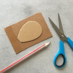 a pair of scissors and a piece of paper with a rock cut out on it