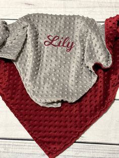 a red and gray blanket with the word lilly on it